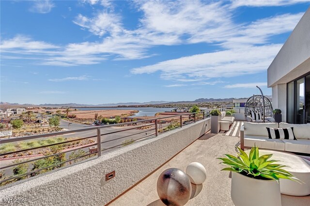 balcony featuring a water and mountain view and an outdoor living space