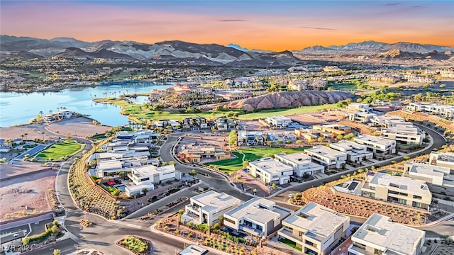 aerial view at dusk featuring a water and mountain view