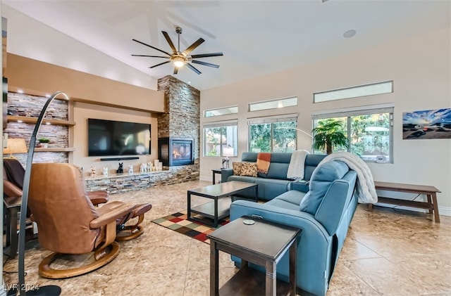 tiled living room with a fireplace, ceiling fan, and high vaulted ceiling