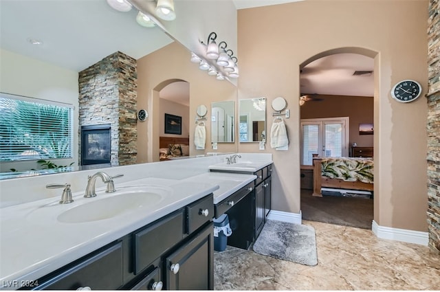 bathroom with a fireplace, vanity, ceiling fan, and vaulted ceiling