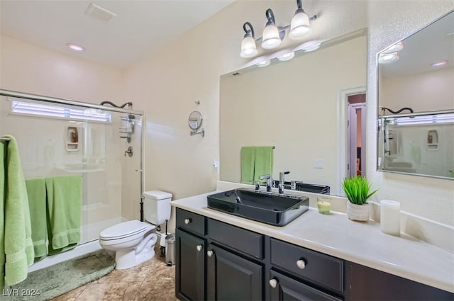 bathroom with toilet, vanity, tile patterned flooring, and a shower with door