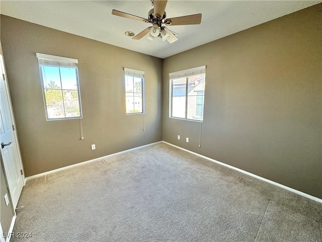 spare room featuring light colored carpet and ceiling fan