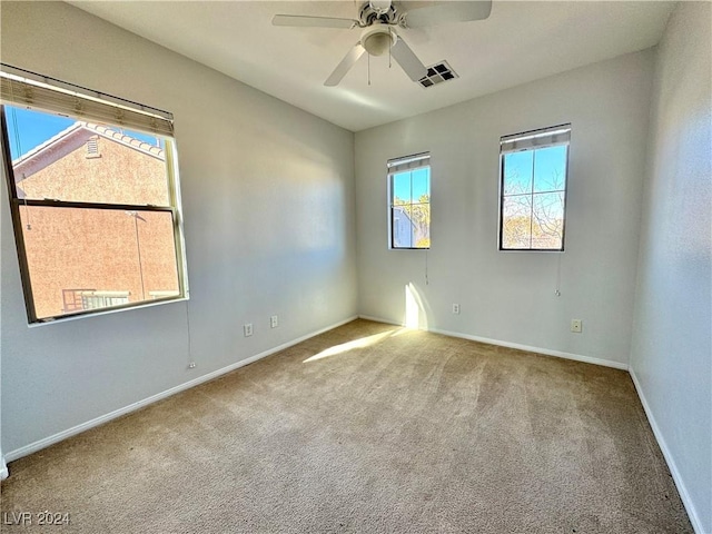 empty room featuring ceiling fan and light carpet