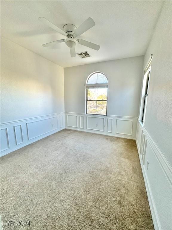 carpeted spare room with ceiling fan