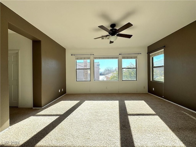 carpeted empty room with plenty of natural light and ceiling fan