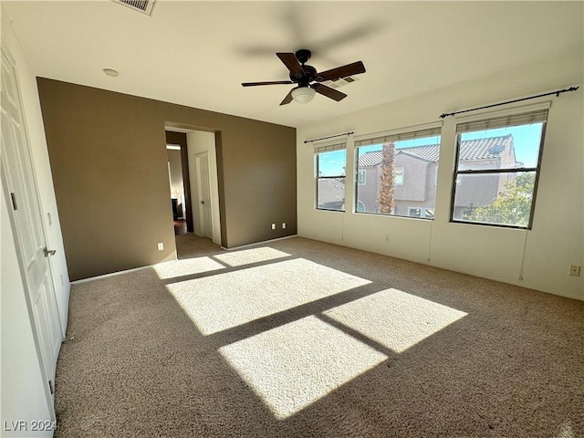 carpeted spare room with ceiling fan