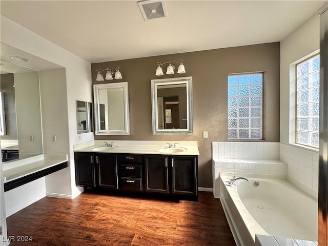 bathroom featuring a bath, wood-type flooring, and vanity