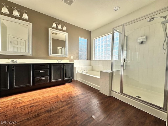 bathroom featuring plus walk in shower, vanity, and hardwood / wood-style flooring