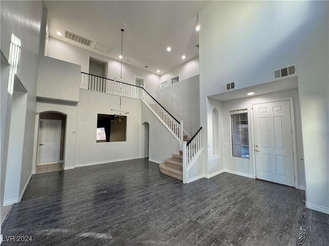 entryway with a high ceiling and dark hardwood / wood-style flooring