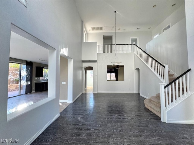 foyer entrance with dark wood-type flooring and a high ceiling