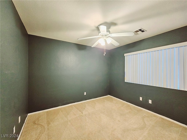 carpeted spare room with ceiling fan