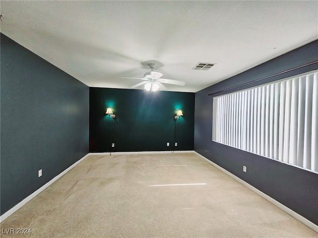 spare room with light carpet, a textured ceiling, and ceiling fan