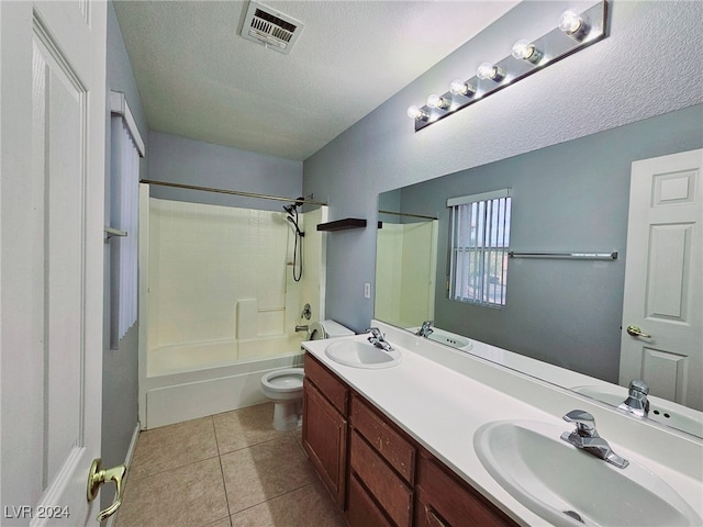 full bathroom featuring tile patterned floors, toilet,  shower combination, a textured ceiling, and vanity