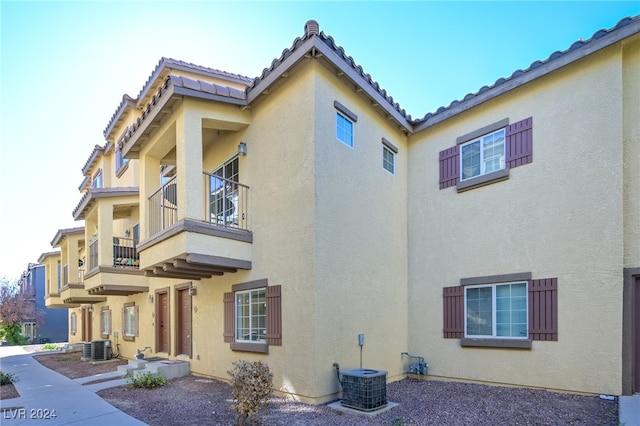 view of side of home with a balcony and central AC