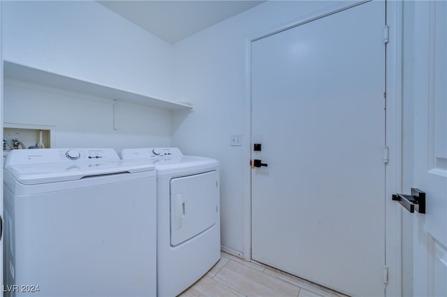 laundry room featuring washing machine and dryer and light tile patterned floors