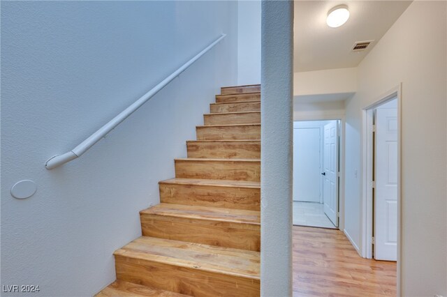 stairs with hardwood / wood-style floors