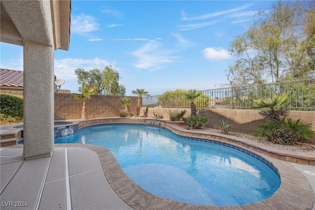 view of pool with a patio area and an in ground hot tub