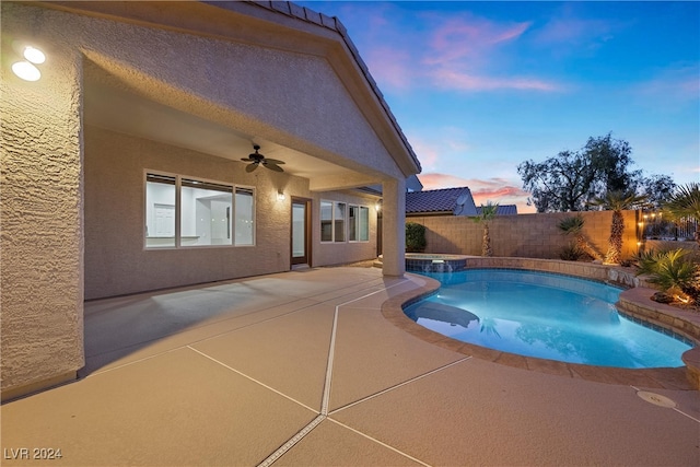 pool at dusk with a patio area and ceiling fan