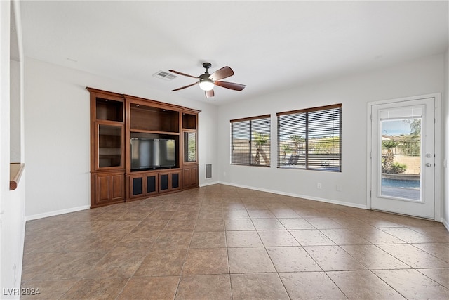 unfurnished living room featuring light tile patterned flooring and ceiling fan