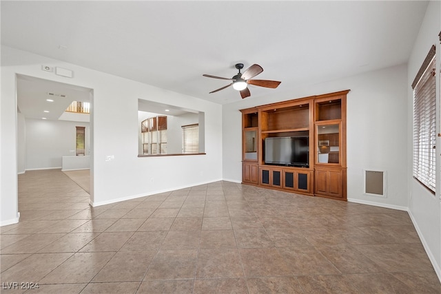 unfurnished living room featuring ceiling fan and light tile patterned floors