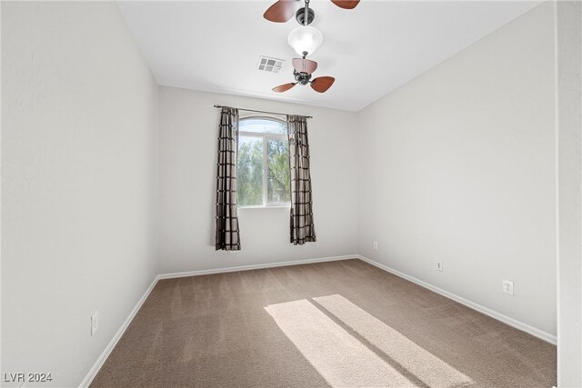 carpeted spare room with ceiling fan