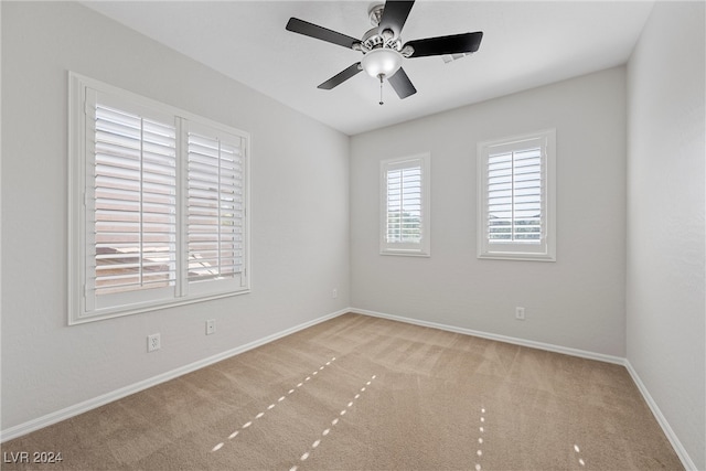 carpeted spare room with ceiling fan