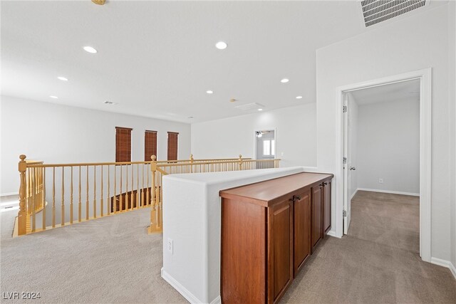 hallway featuring light colored carpet