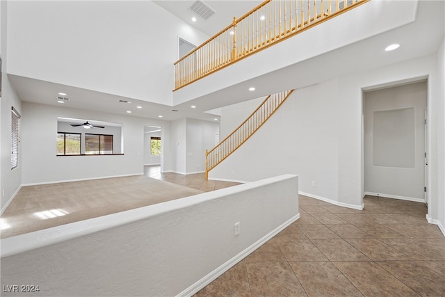 hall with a high ceiling and tile patterned flooring