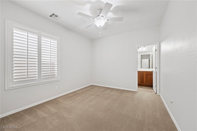 carpeted spare room featuring ceiling fan