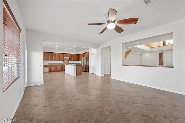 unfurnished living room with tile patterned flooring and ceiling fan