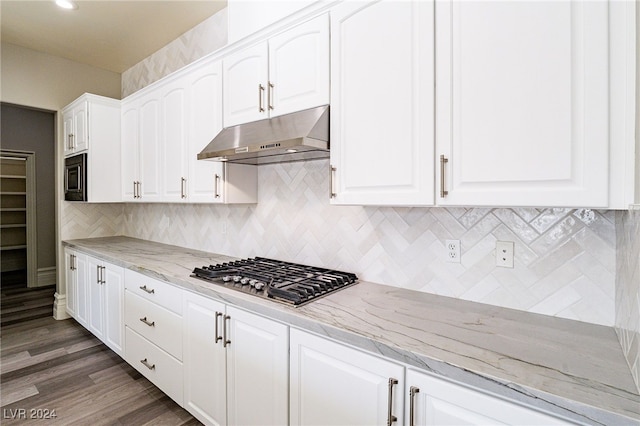 kitchen with light stone counters, white cabinets, stainless steel gas cooktop, tasteful backsplash, and dark hardwood / wood-style floors