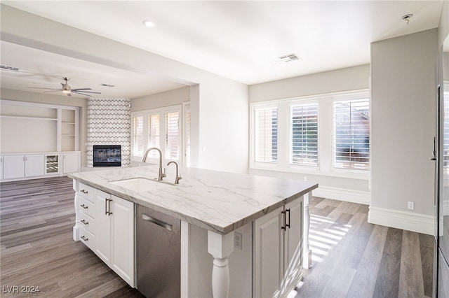 kitchen with white cabinetry, a wealth of natural light, sink, and a center island with sink