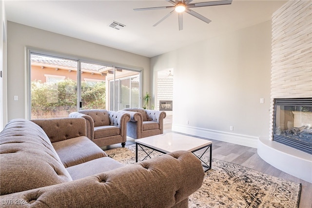 living room with a fireplace, hardwood / wood-style flooring, and ceiling fan