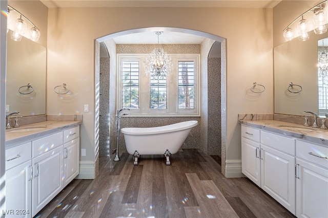 bathroom with vanity, hardwood / wood-style flooring, a chandelier, and a washtub