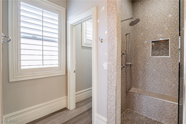 bathroom featuring hardwood / wood-style floors and tiled shower