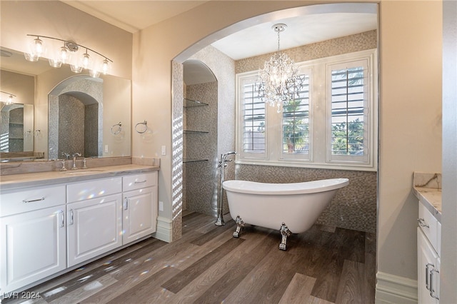 bathroom featuring wood-type flooring, vanity, a bathtub, and a notable chandelier