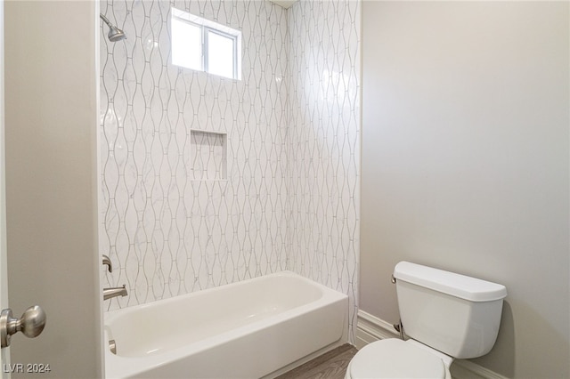 bathroom featuring toilet, tiled shower / bath combo, and hardwood / wood-style floors