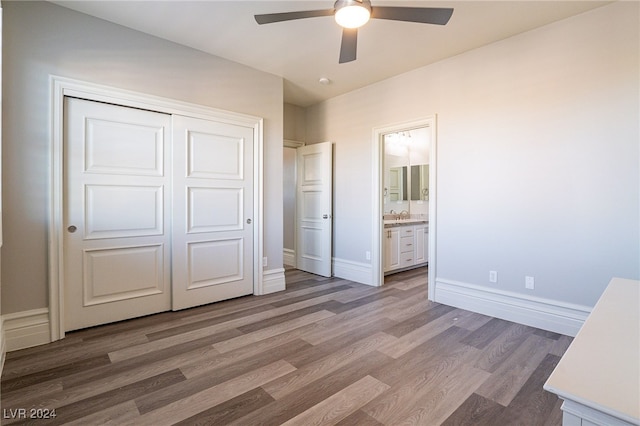 unfurnished bedroom featuring hardwood / wood-style flooring, ceiling fan, a closet, and ensuite bathroom