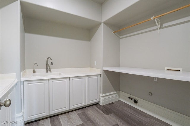 laundry room featuring sink and hardwood / wood-style floors