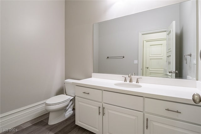 bathroom with hardwood / wood-style flooring, vanity, and toilet