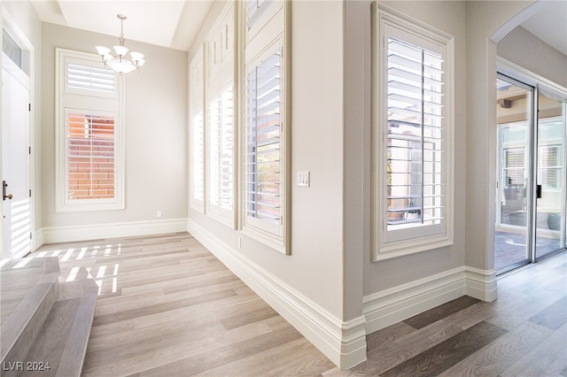 interior space featuring an inviting chandelier and light hardwood / wood-style flooring