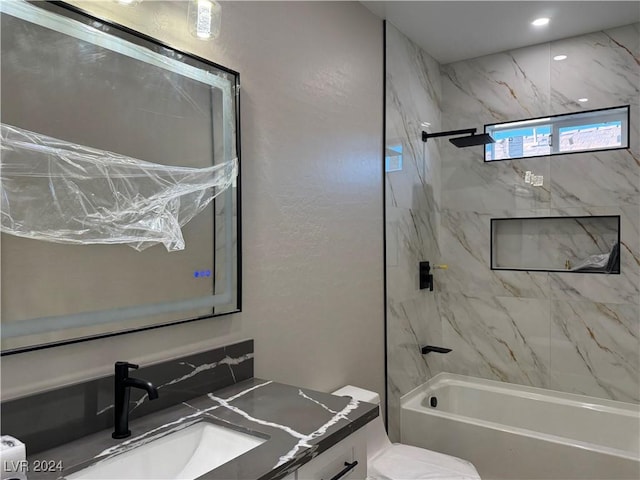 full bathroom featuring toilet, tiled shower / bath combo, and vanity