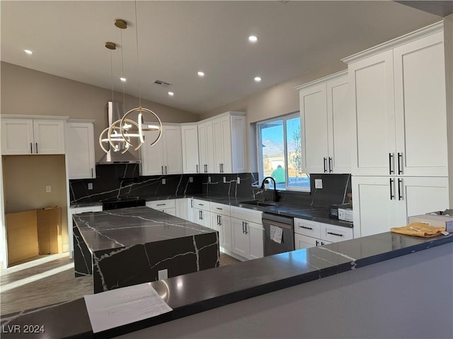 kitchen with stainless steel dishwasher, hanging light fixtures, lofted ceiling, white cabinetry, and sink