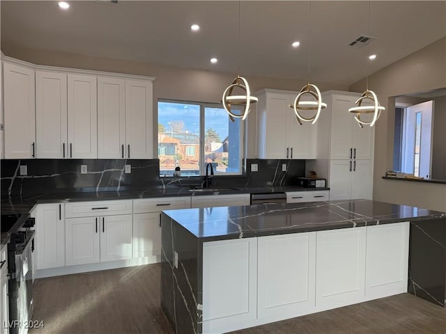 kitchen featuring a kitchen island, white cabinetry, pendant lighting, and vaulted ceiling