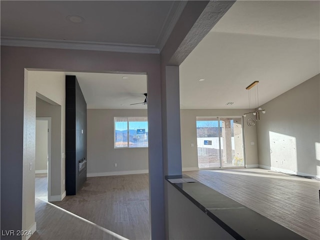 unfurnished room featuring wood-type flooring, ceiling fan, and crown molding