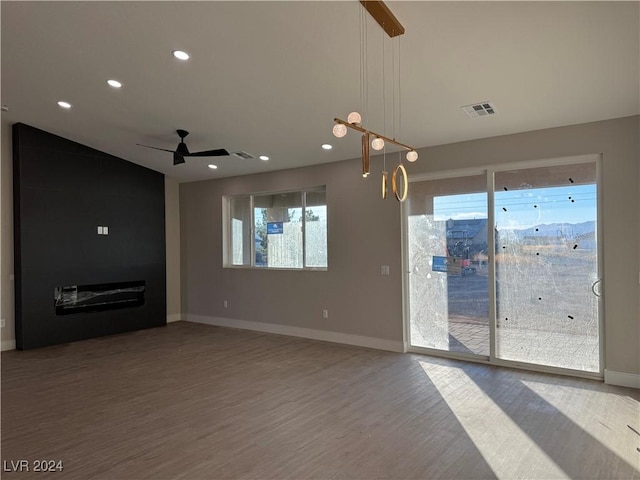 unfurnished living room with hardwood / wood-style floors, ceiling fan, and plenty of natural light