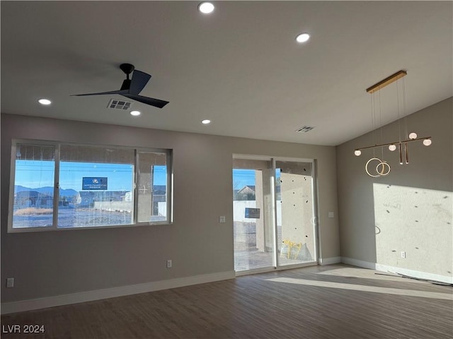 spare room with wood-type flooring, ceiling fan, and a wealth of natural light