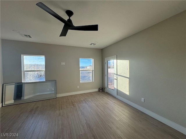 empty room with hardwood / wood-style flooring and ceiling fan