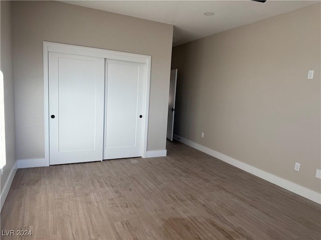 unfurnished bedroom featuring a closet and light hardwood / wood-style floors