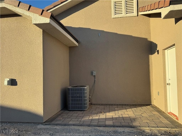 view of property exterior featuring central air condition unit and a patio